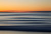 A beautiful sunset as clean swell lines head to a Cornish shore