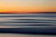 A beautiful sunset as clean swell lines head to a Cornish shore