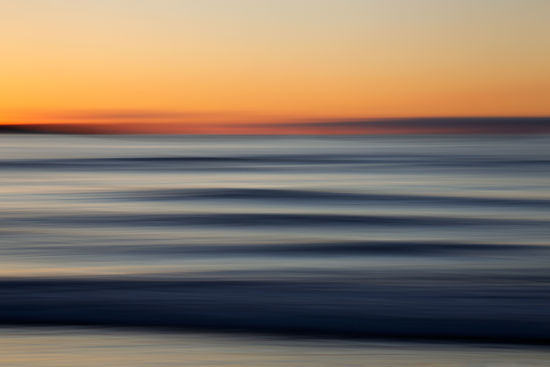 A beautiful sunset as clean swell lines head to a Cornish shore