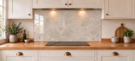 Soft Greige Limestone Effect Glass Splashback as a wide panel under the cooker hood in a white shaker kitchen