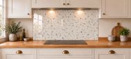 Ivory Terrazzo Effect Glass Splashback as a wide panel under the cooker hood in a white shaker kitchen