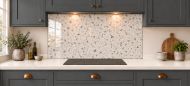 Ivory Terrazzo Effect Glass Splashback as a wide panel under the cooker hood in a charcoal shaker kitchen